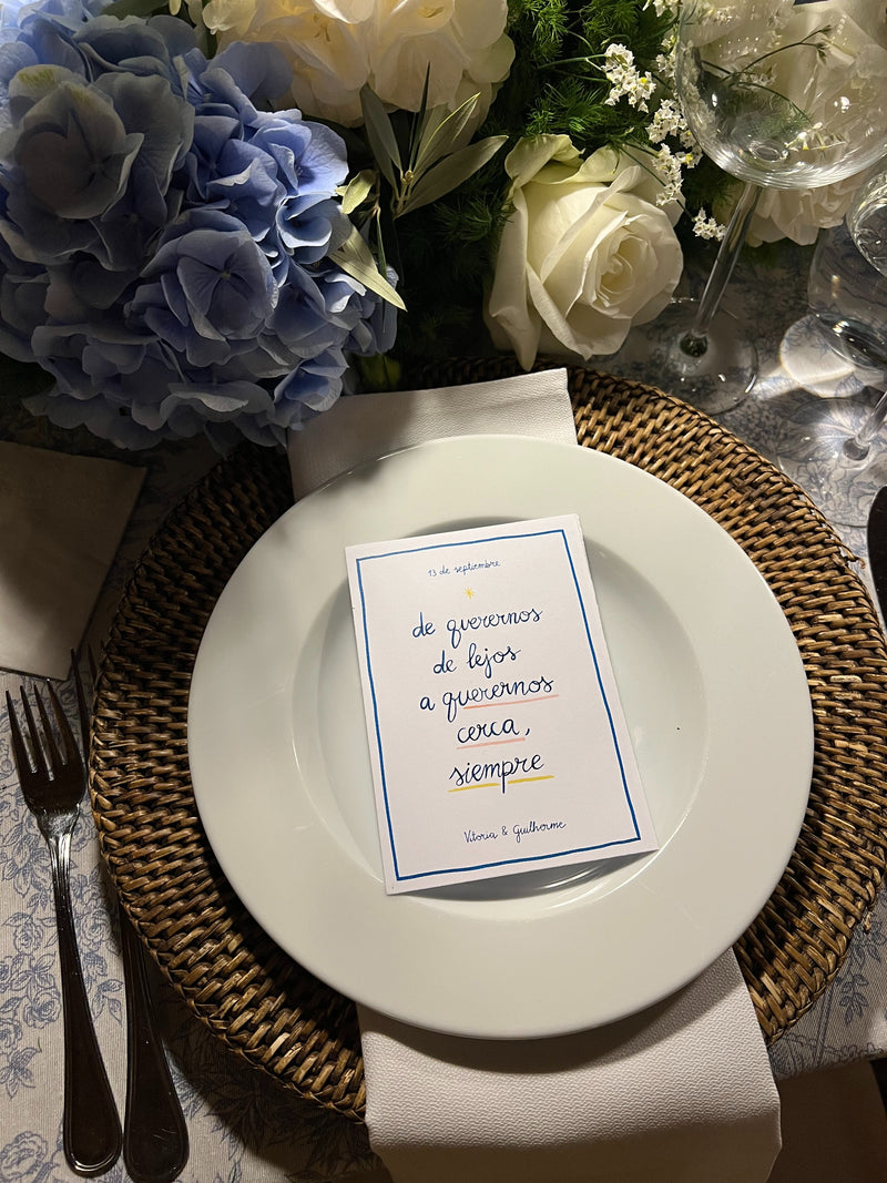 Wedding table setting with flowers, a plate, and a handwritten card.